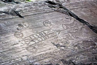 Engraving scene in Camonica Valley showing four wheeled chariot, pulled by two horses.